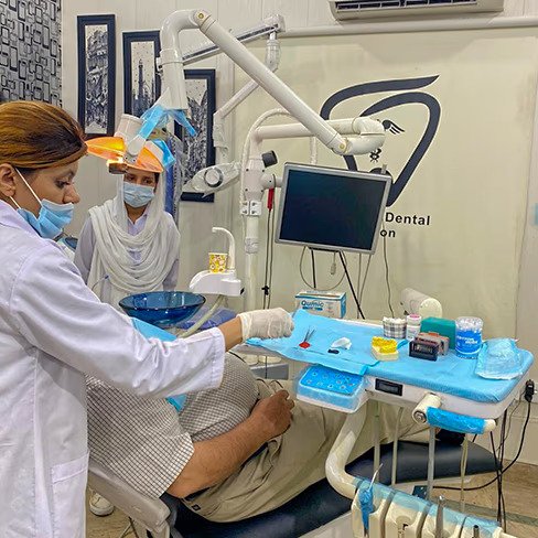 Dr. Sheraz and an assistant treating a patient at Smile Care